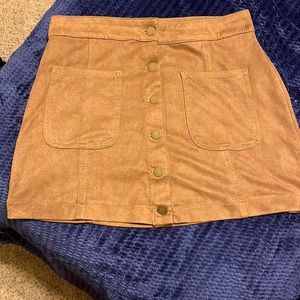 A very cute brown leather like high rise skirt with gold buttons.